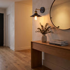 Industrial Saucer Shade Iron Wall Light in a hallway above a timber console