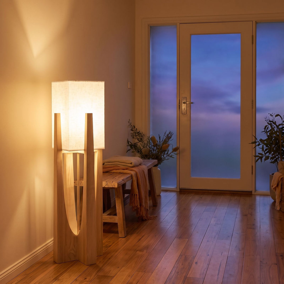 Wood frame fabric shade floor lamp beside an entry hall bench