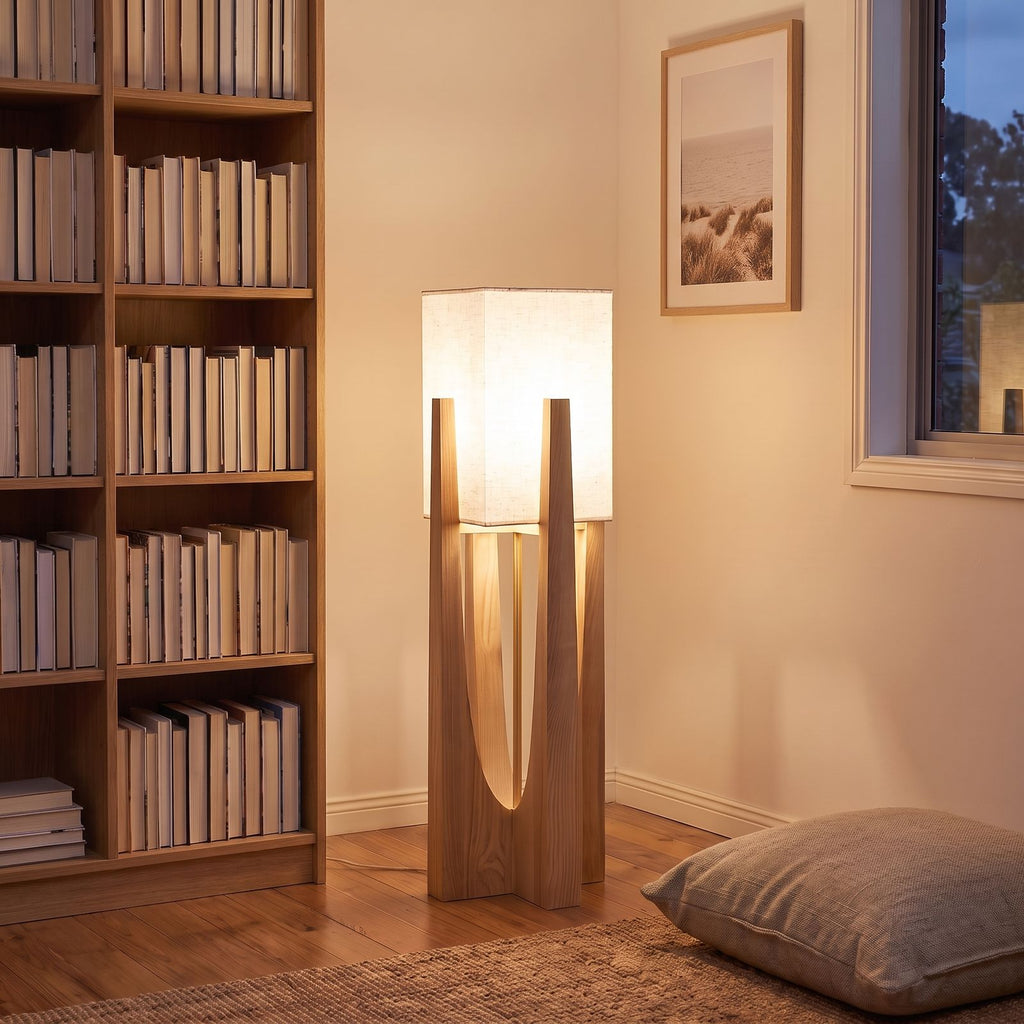 Wood frame fabric shade floor lamp in a reading corner beside a bookshelf