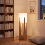 Wood frame fabric shade floor lamp in a reading corner beside a bookshelf