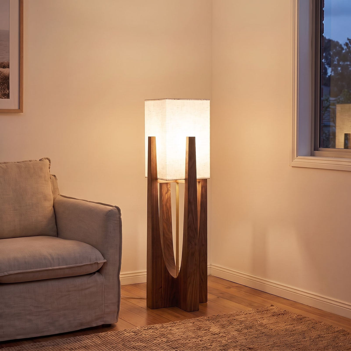 Japandi Wood Frame Fabric Shade Floor Lamp in walnut beside an armchair in a living room corner