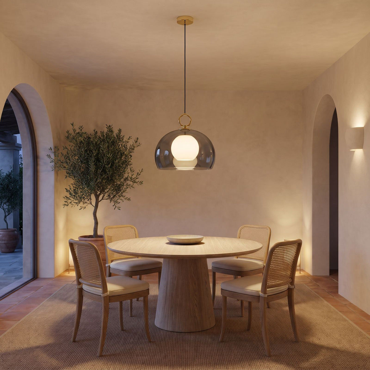 The smoked grey glass dome pendant above a round dining table in a villa dining room