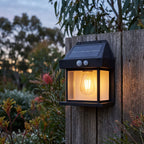 Lantern Shape Filament LED Solar Sensor Wall Light on a timber fence at dusk