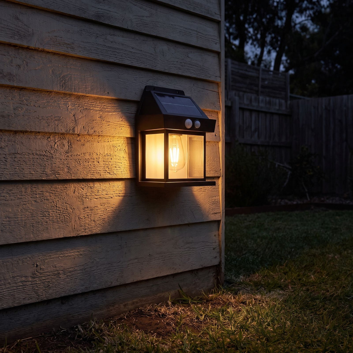 Lantern shape solar sensor wall light on a garden shed wall at night