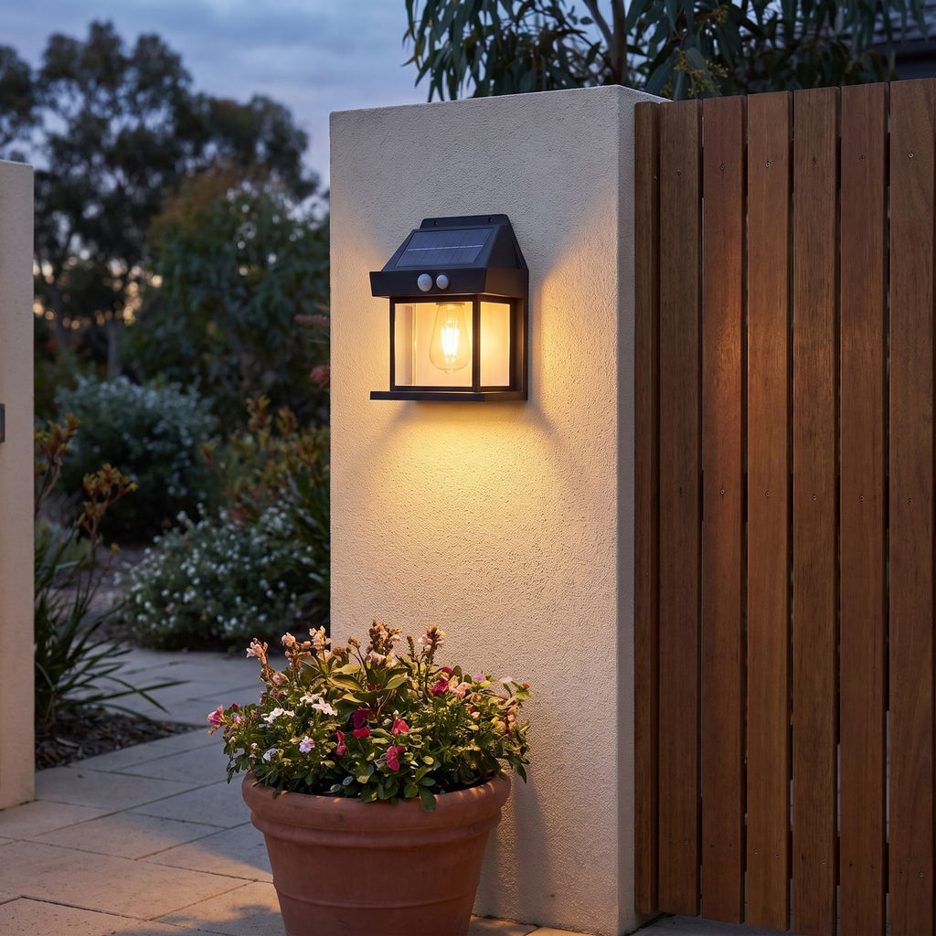 Lantern shape solar sensor wall light on a courtyard wall beside a gate