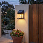 Lantern shape solar sensor wall light on a courtyard wall beside a gate