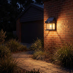 Lantern shape solar sensor wall light on a garage side wall above a path