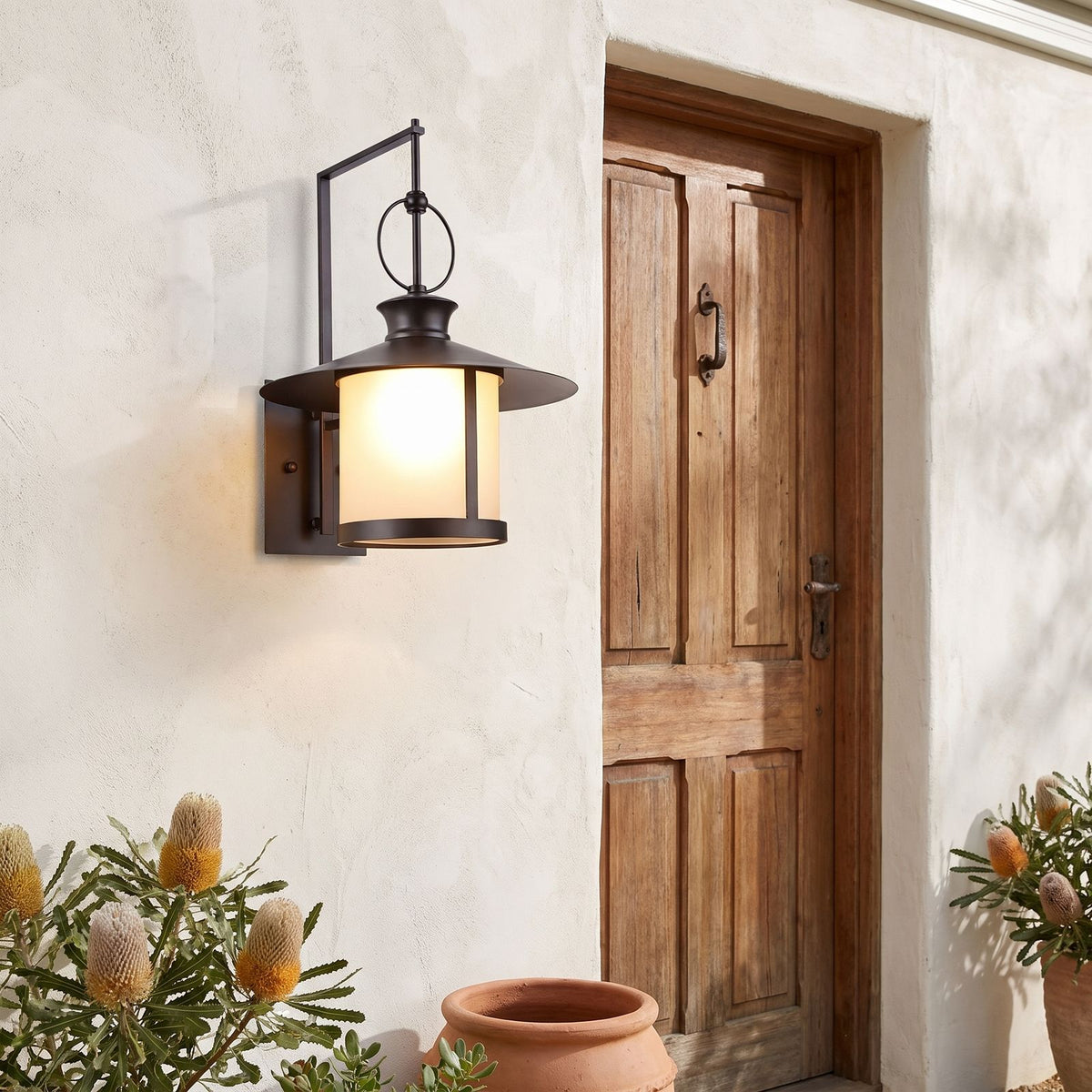 Large Black Iron Lantern Outdoor Wall Light beside a timber front door