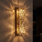 Layered Crystal Ribbon LED Wall Light glowing on a plaster wall at night