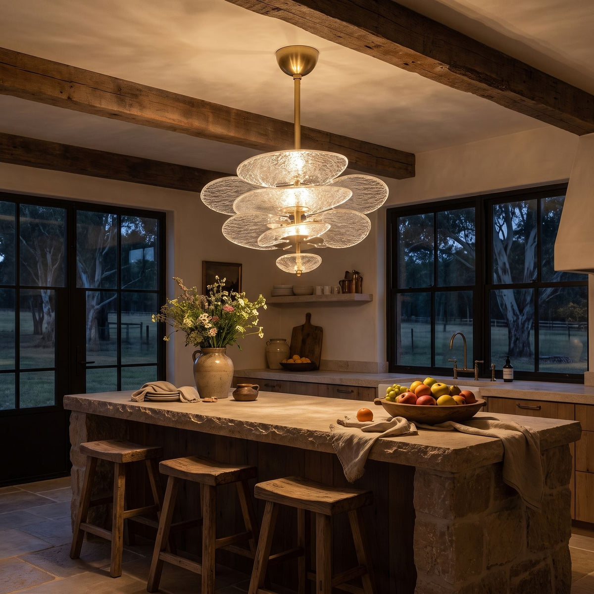 Layered Glass Leaf Chandelier above a kitchen island at night
