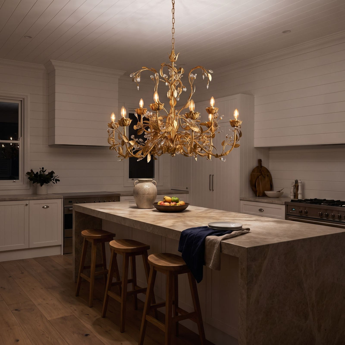 Leaf Branch Iron and Crystal Chandelier above a kitchen island at night