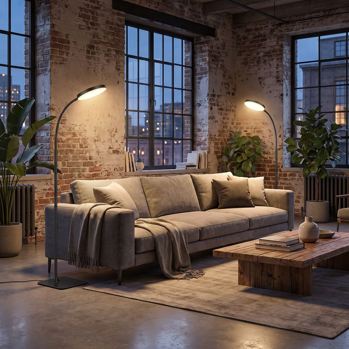 Pair of gooseneck floor lamps at each end of a sofa in a loft living room in the evening