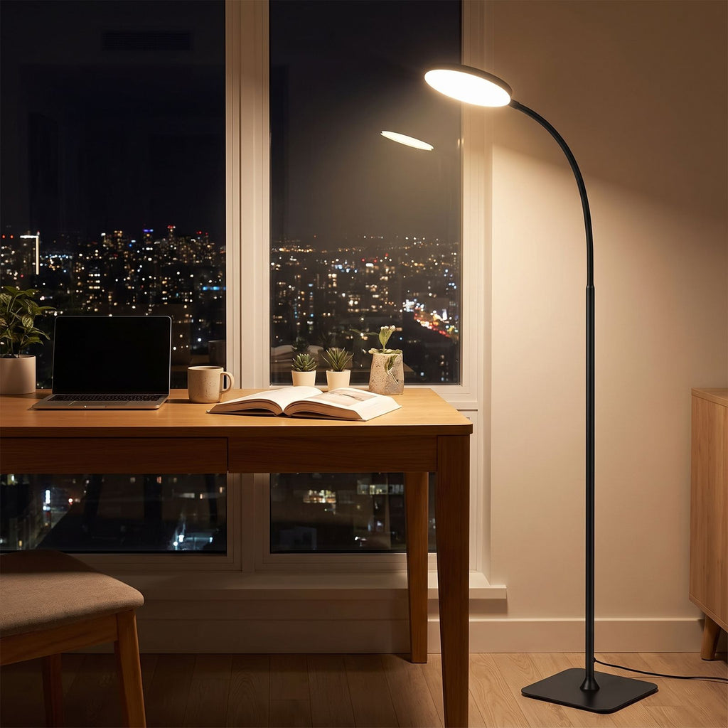 Gooseneck floor lamp over a desk in an apartment home office at night