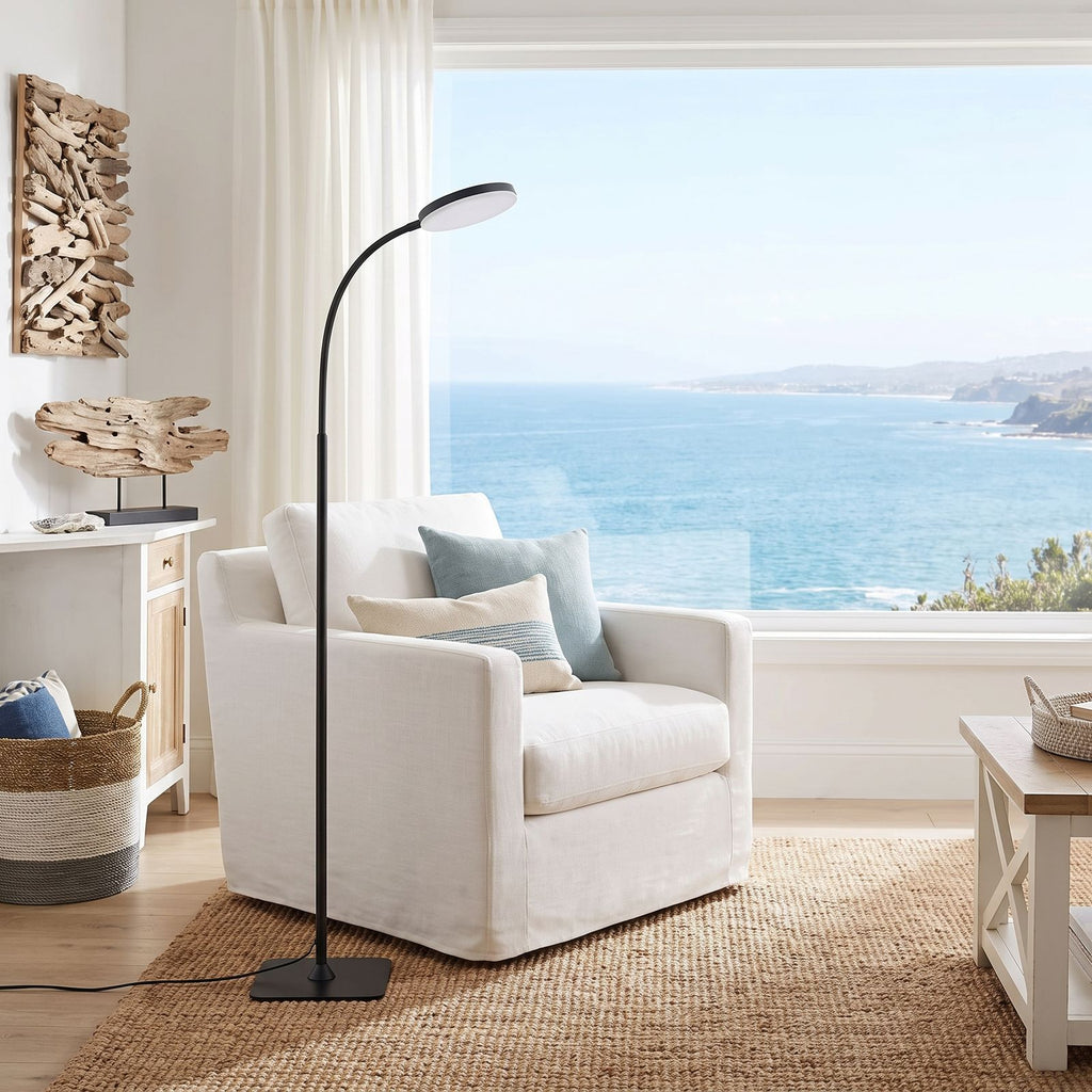 Gooseneck floor lamp beside a linen armchair in a coastal living room