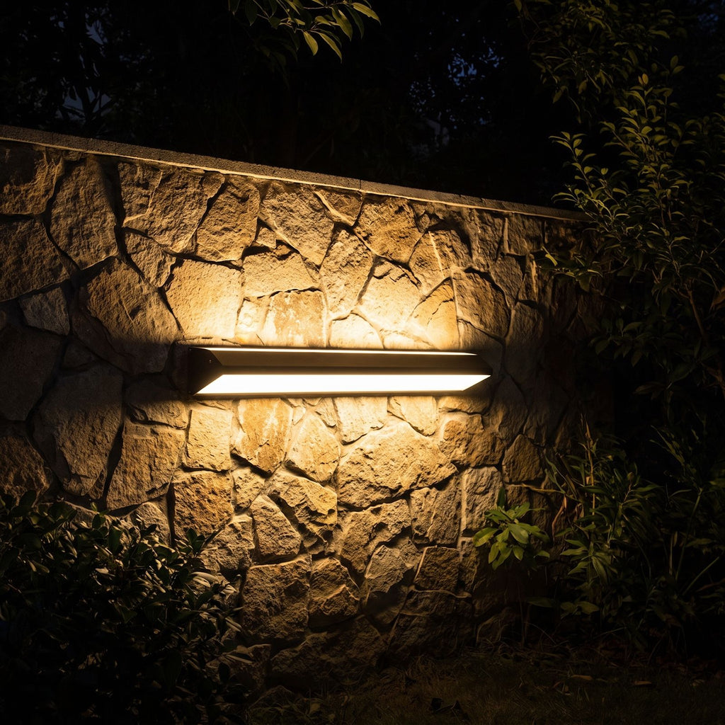 Long Linear Up Down Outdoor Wall Light glowing on a garden wall at night