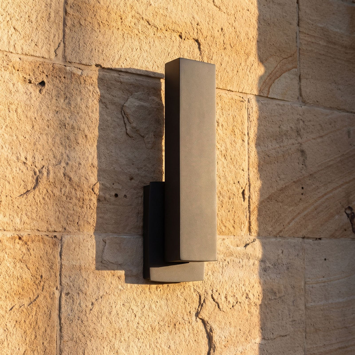 Matte Black Aluminium Lantern Outdoor Wall Light, close view at 45 degrees on a stone wall