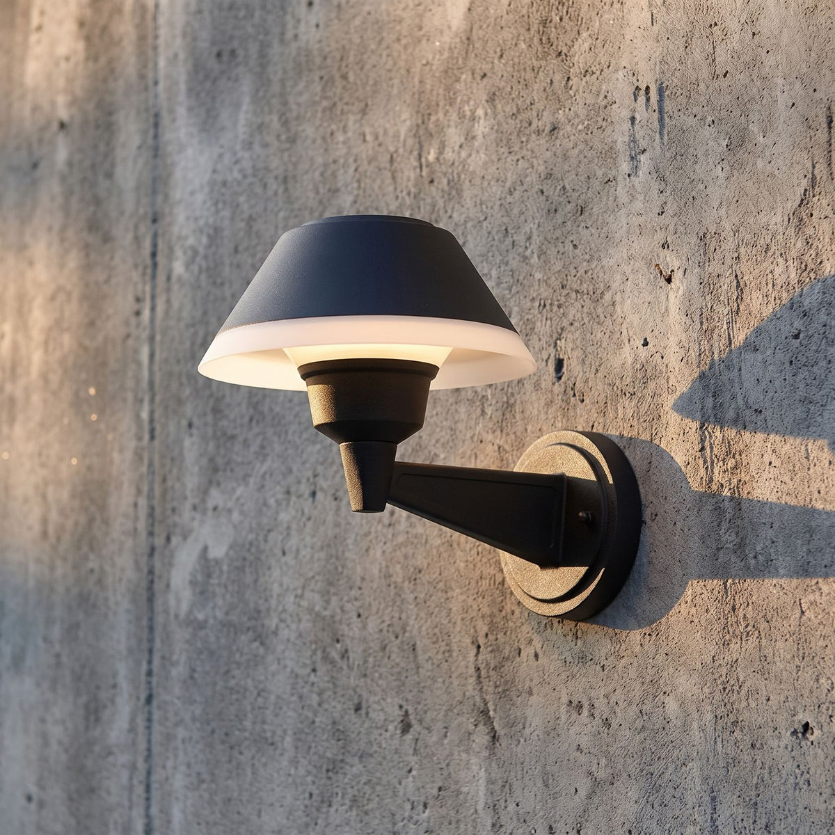 Matte Black Bowl Outdoor Wall Light, close view at 45 degrees on a stone wall