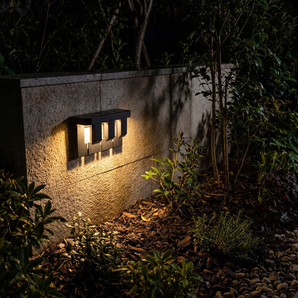 Matte Black Metal Outdoor Wall Light glowing on a garden wall at night