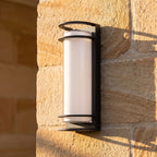Metal and Acrylic Courtyard Outdoor Wall Light, close view at 45 degrees on a stone wall