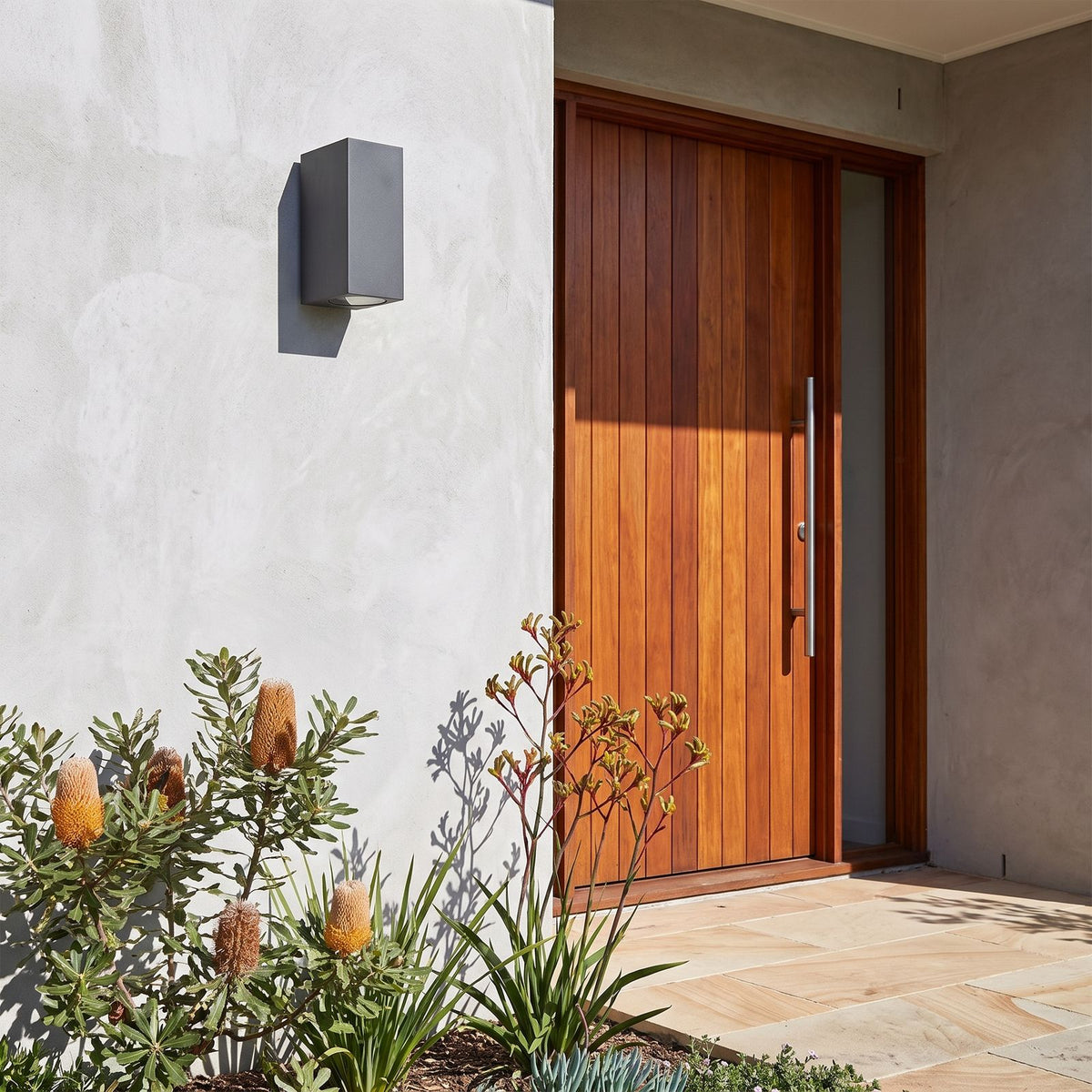 Metal and Glass GU10 Outdoor Wall Light beside a timber front door