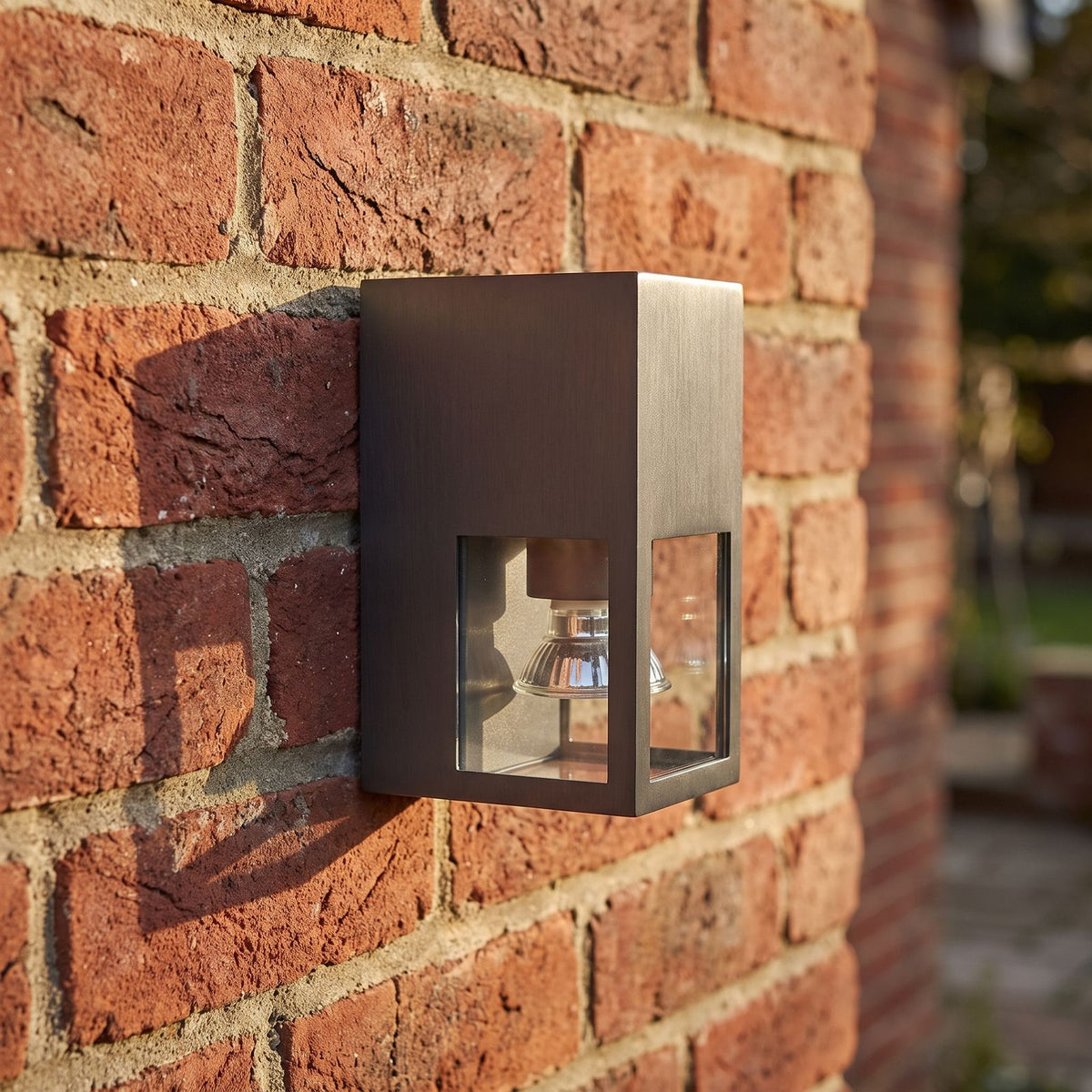Metal and Glass GU10 Outdoor Wall Light, close view at 45 degrees on a stone wall