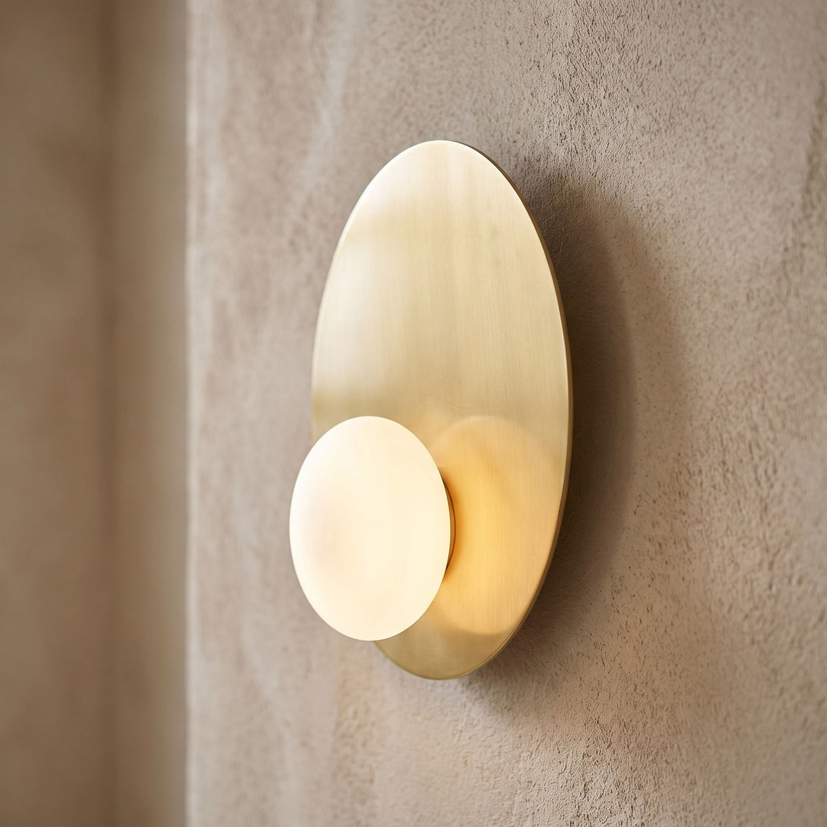 Metal Disc and Opal Glass Wall and Ceiling Light, close view at 45 degrees on a plaster wall