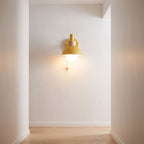 Metal dome pull chain wall light on a hallway wall