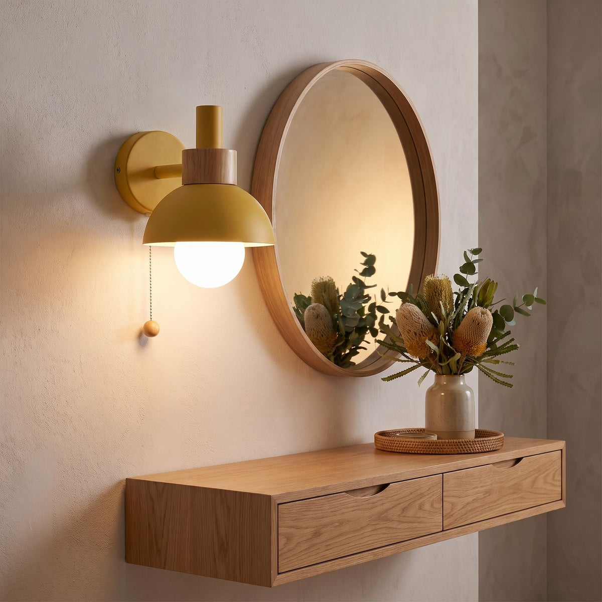 Metal dome pull chain wall light beside a round mirror in an entry hall