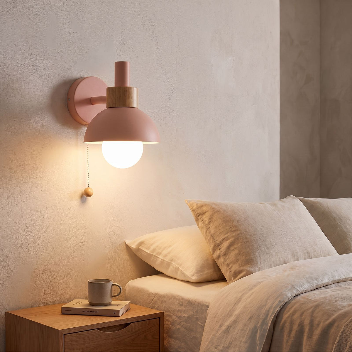 Metal Dome and Wood Collar Pull Chain Wall Light in pink beside a bed