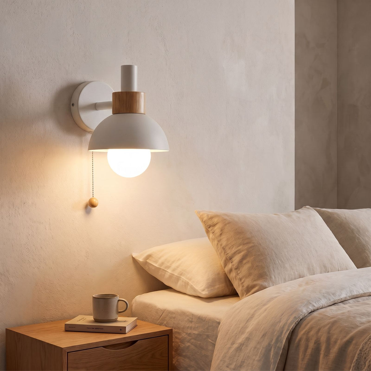 Metal Dome and Wood Collar Pull Chain Wall Light in white beside a bed