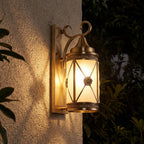 Middle Eastern Style Brass Lantern Outdoor Wall Light glowing on a garden wall at night