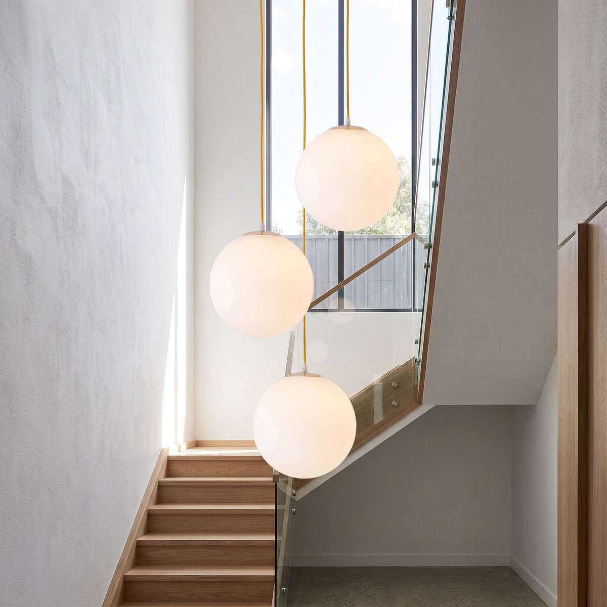 Milky Glass Globe Pendant Light in a group of three in a stairwell