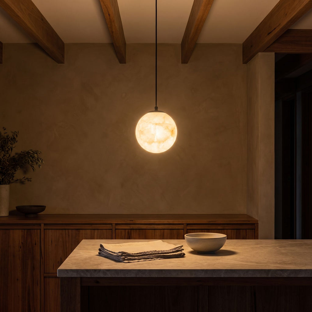 Mini Alabaster Globe LED Pendant Light glowing against a plaster wall at night