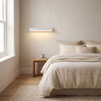 Minimalist White Metal Bar LED Wall Light on a bedroom wall beside the bed