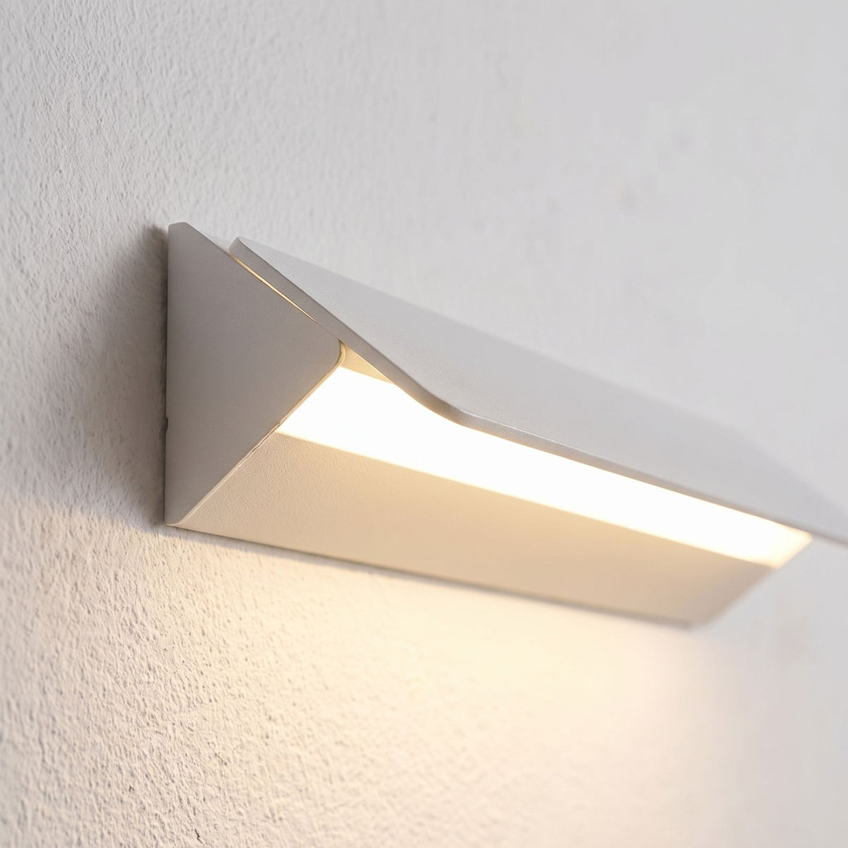 Minimalist White Metal Bar LED Wall Light, close view at 45 degrees on a plaster wall