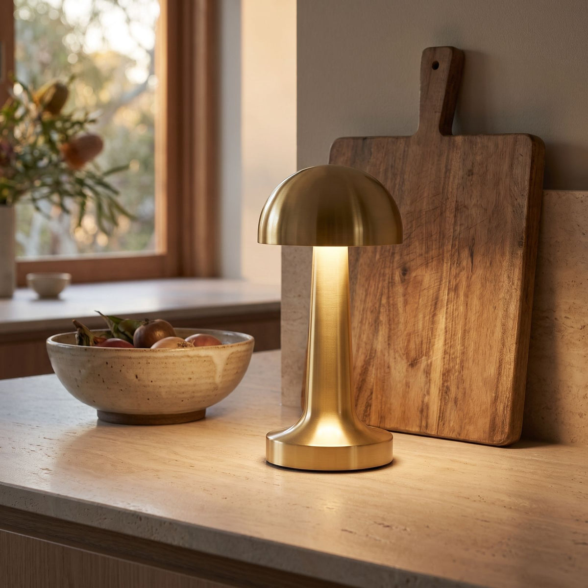 Gold mushroom dome table lamp on a stone kitchen bench