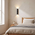 Narrow Aluminium Bar Up Down Wall Light on a bedroom wall beside the bed