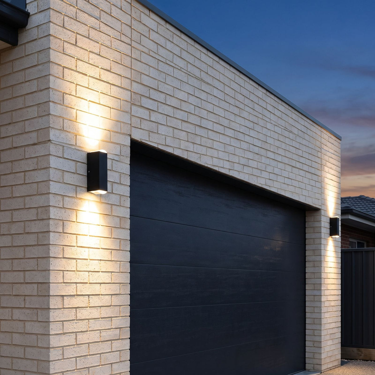Black up down outdoor wall lights either side of a garage door