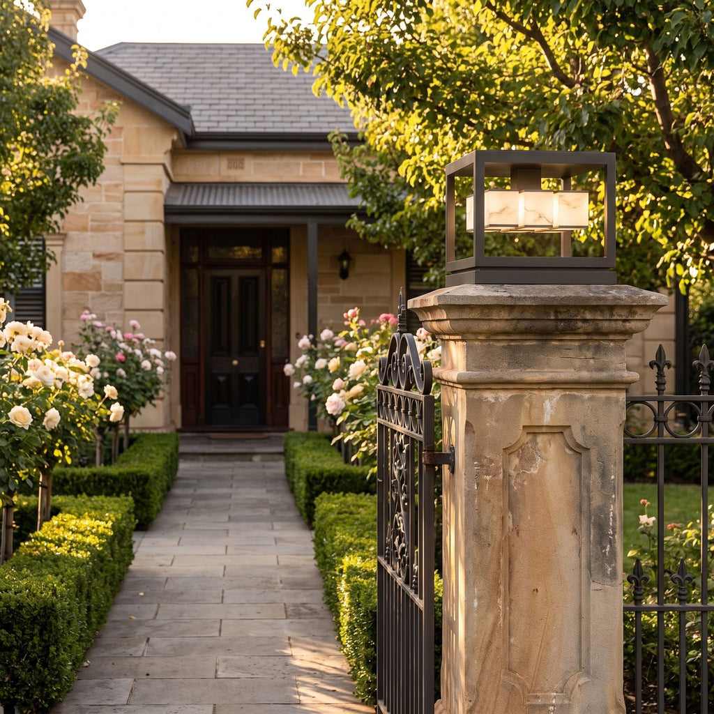 Open Square Frame Stainless Steel Deck Post Light on a gate pillar at the front entrance at golden hour