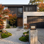 Open Square Frame Stainless Steel Deck Post Light at the driveway entrance, wide view of the house