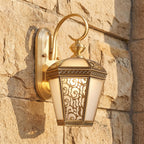 Ornate Brass and Glass Outdoor Wall Light, close view at 45 degrees on a stone wall