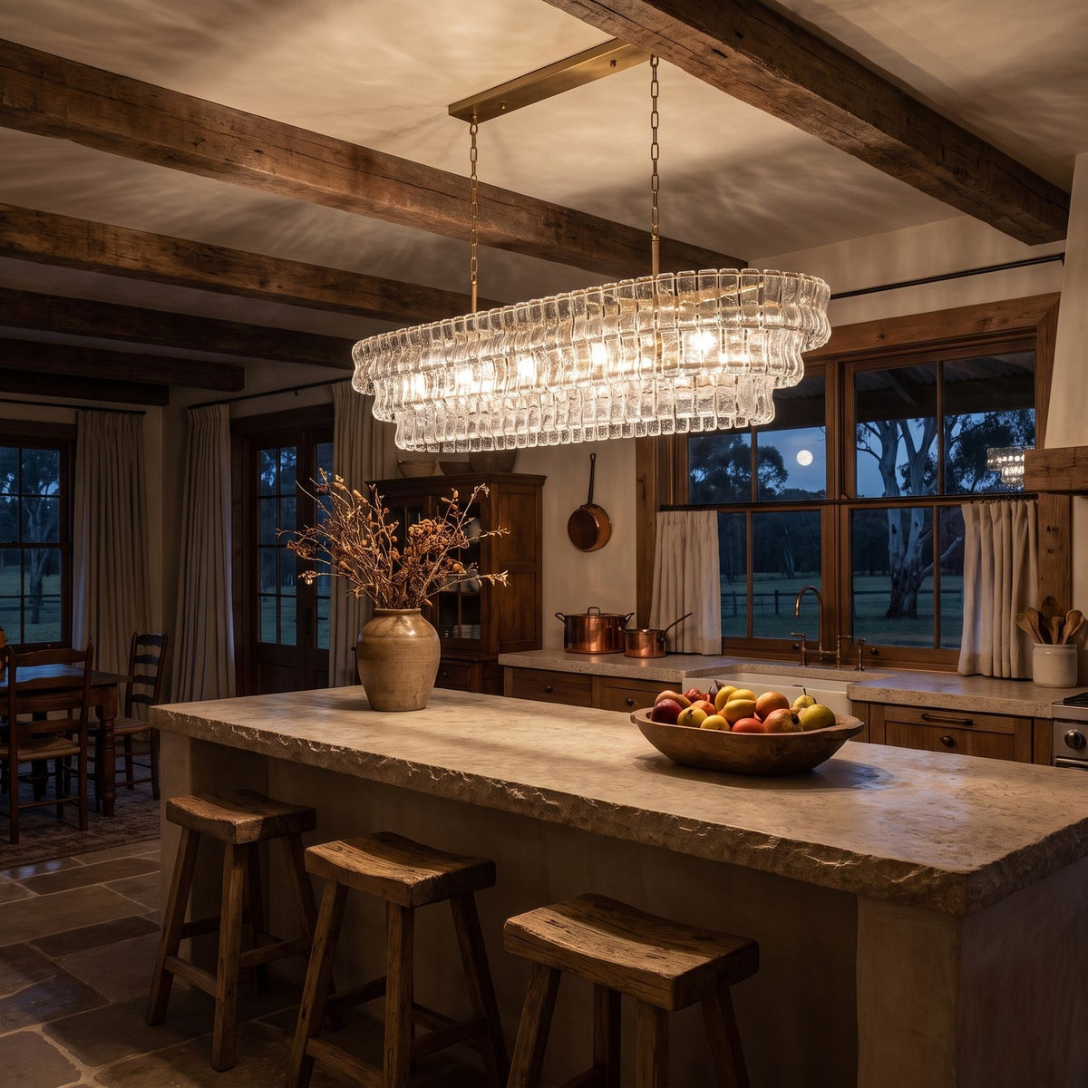 Oval Tiered Textured Glass Chandelier above a kitchen island at night
