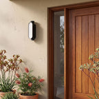 Oval Up Down Acrylic Outdoor Wall Light beside a timber front door