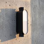 Oval Up Down Acrylic Outdoor Wall Light, close view at 45 degrees on a stone wall