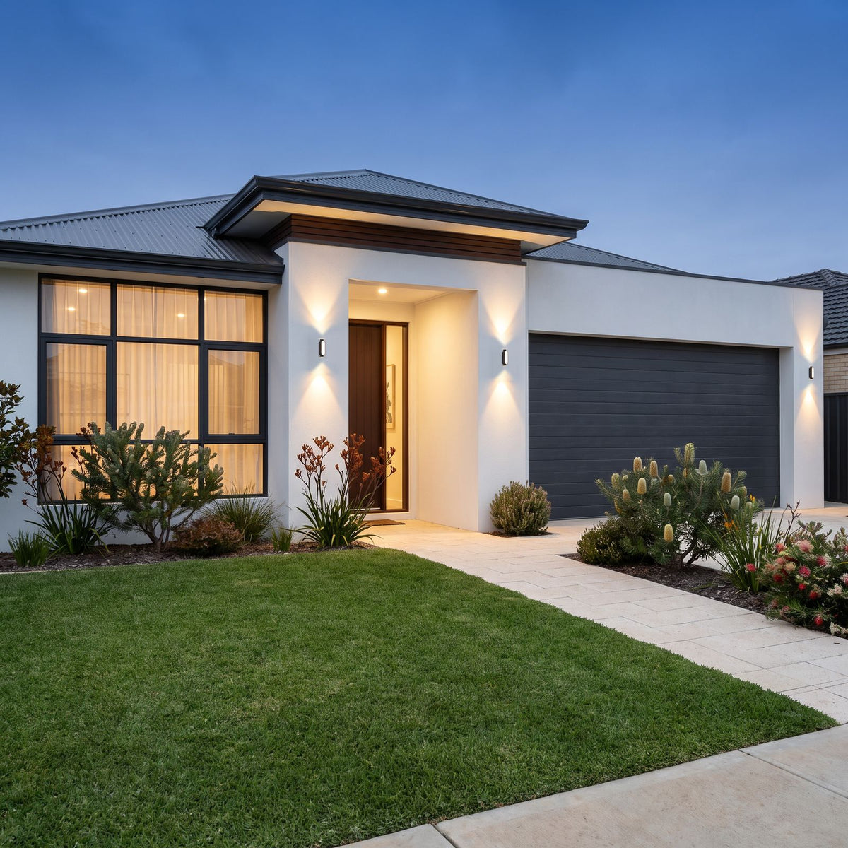 Oval Up Down Acrylic Outdoor Wall Lights beside the front door and garage of a single-storey home with a front lawn