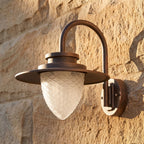 Pine Cone Glass Gooseneck Outdoor Wall Light, close view at 45 degrees on a stone wall