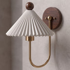 Pleated Ceramic Shade Bedside Wall Light, close view at 45 degrees on a plaster wall