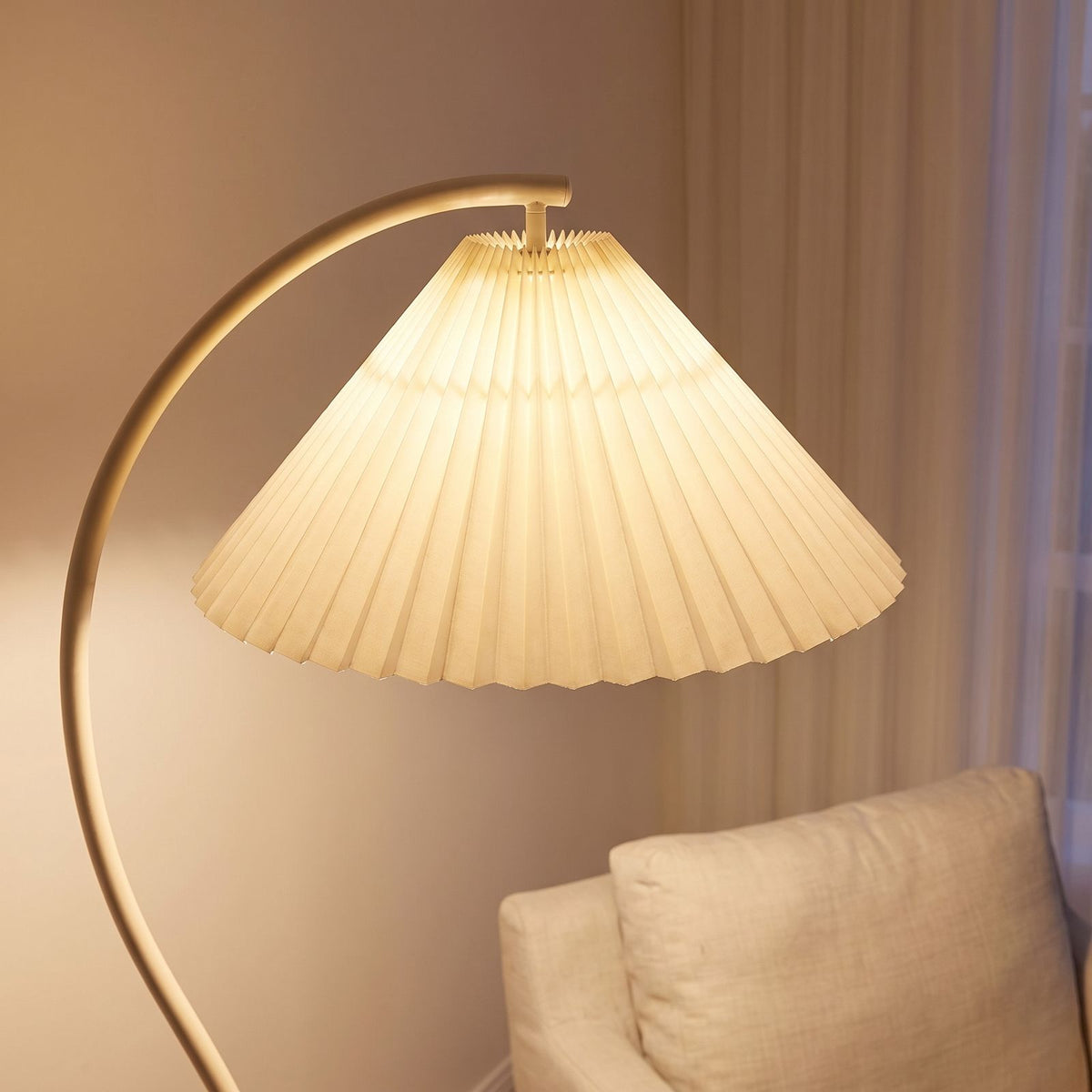 Close-up of the cream pleated fabric shade on the curved stem