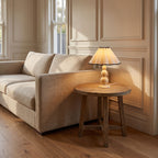 Scalloped Pleated Shade Bobbin Table Lamp in cream with black trim on a side table beside a sofa in a classic living room