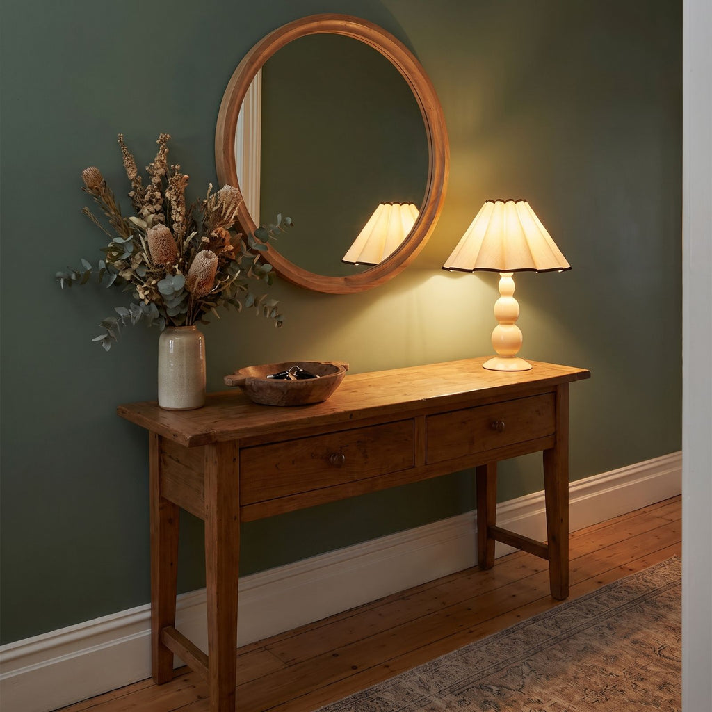 Scalloped Pleated Shade Bobbin Table Lamp on a timber console in an entry hallway in the evening